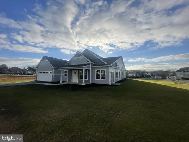 a view of a house next to a big yard with wooden fence