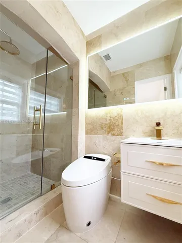a bathroom with a sink a mirror a vanity and shower