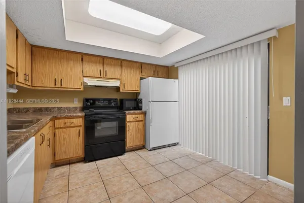 a kitchen with a refrigerator sink and cabinets
