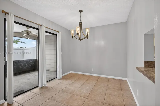 a view of a hallway with wooden floor and a chandelier