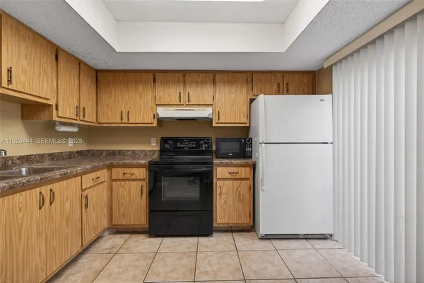 a kitchen with a refrigerator sink and cabinets