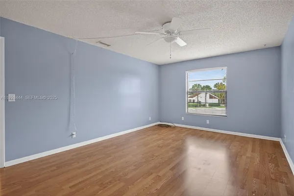 an empty room with wooden floor and window