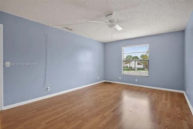 an empty room with wooden floor and window