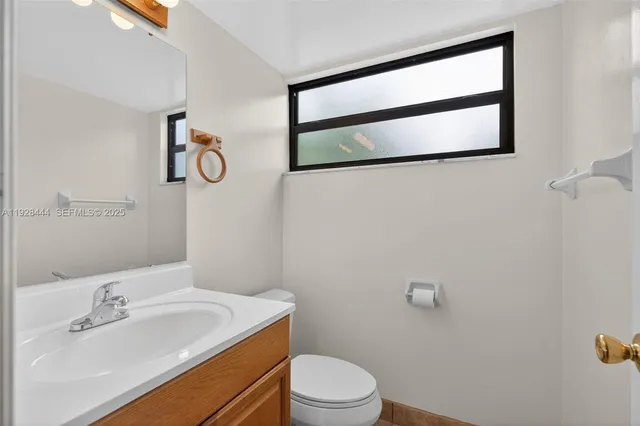 a bathroom with a sink mirror vanity and toilet