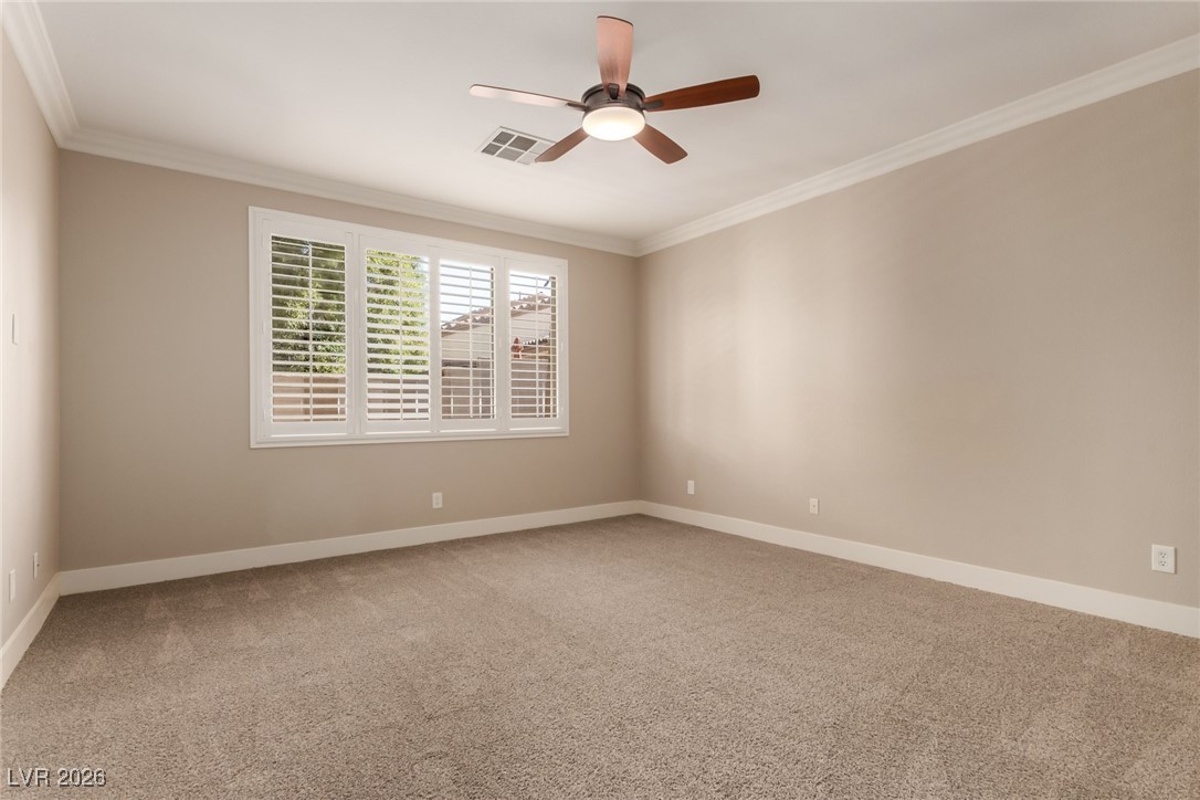 264 Pointe Ranier Avenue Henderson, NV 89012 - Photo 13 of 47 Spare room with ornamental molding, light carpet, and a ceiling fan