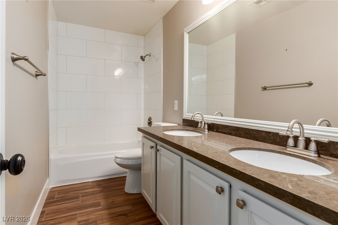264 Pointe Ranier Avenue Henderson, NV 89012 - Photo 34 of 47 Bathroom featuring double vanity, shower combination, and dark wood-style floors