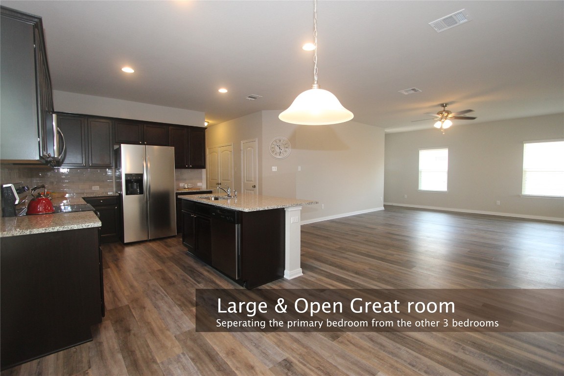 1066 Gaelic Drive Georgetown, TX 78626 - Photo 1 of 1 a view of a kitchen with kitchen island a sink wooden floor and a refrigerator