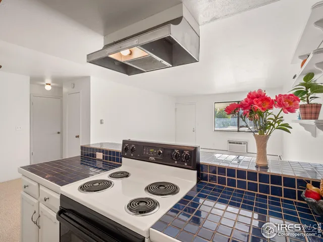 a view of kitchen island with stove and cabinets