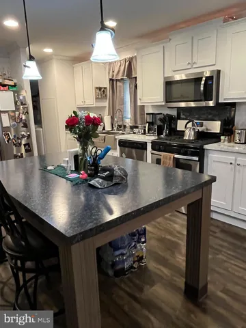a kitchen with stainless steel appliances a dining table and chairs
