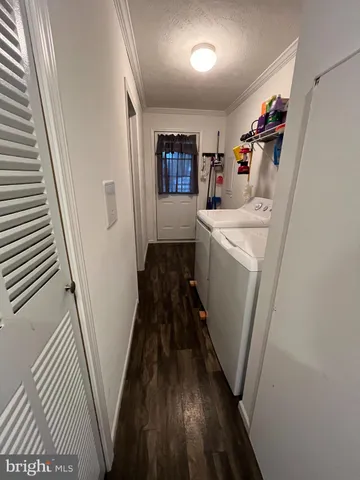 a storage room with fridge and wooden floor