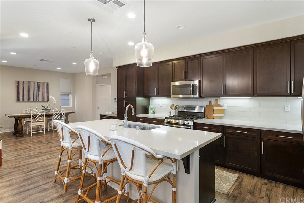 2189 Miner Street Costa Mesa, CA 92627 - Photo 7 of 21 a kitchen with a table chairs microwave and cabinets