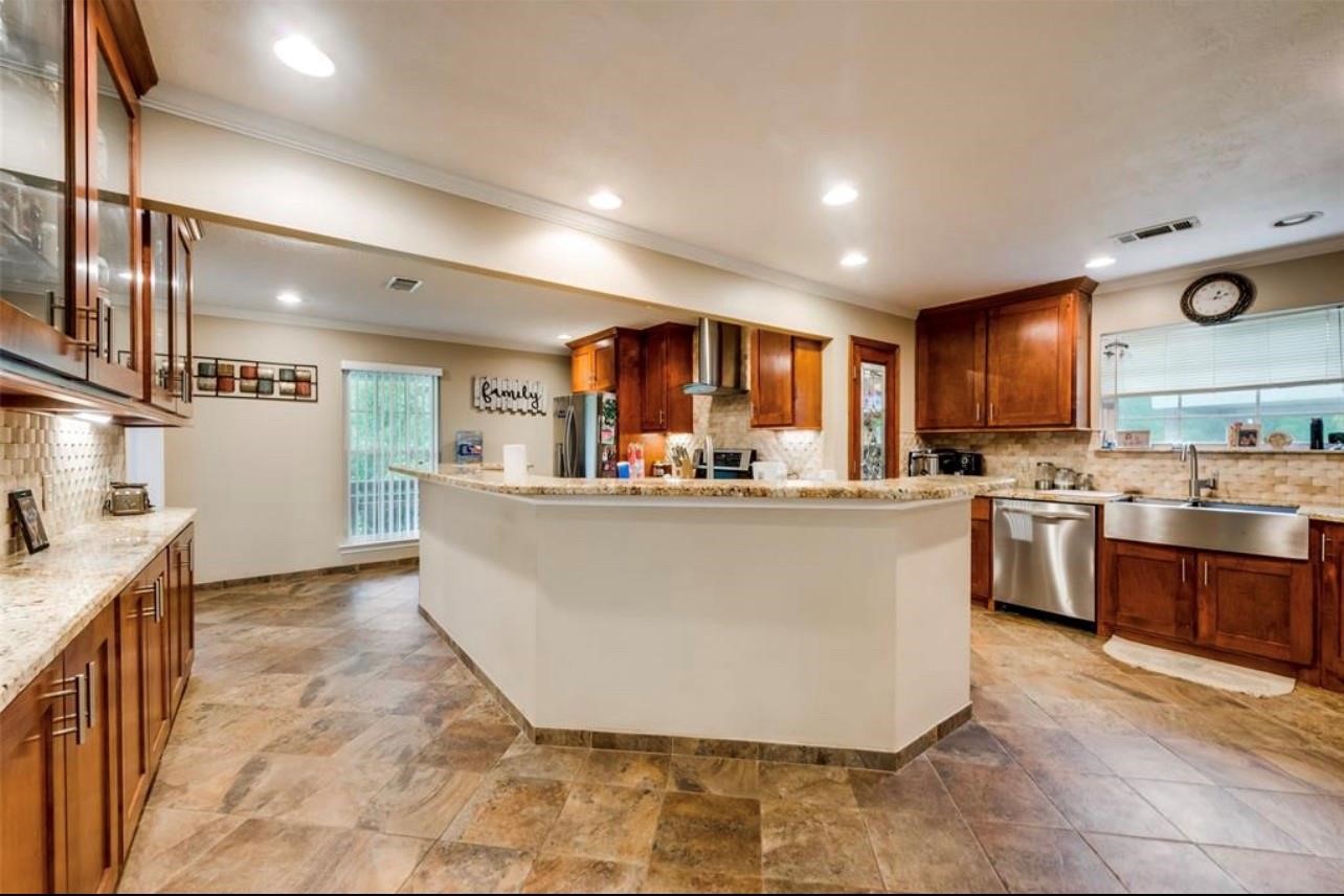 215 Reidland Road Crosby, TX 77532 - Photo 23 of 37 a view of kitchen with kitchen island stainless steel appliances a sink a stove top oven a counter top space and cabinets