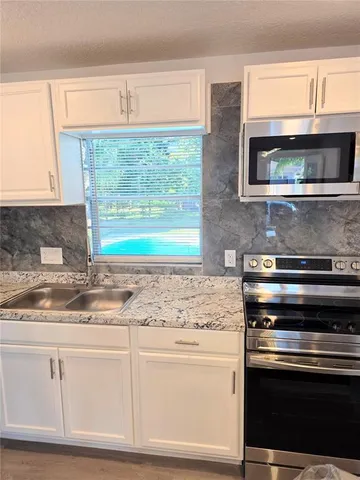 a kitchen with stainless steel appliances white cabinets and a granite counter tops