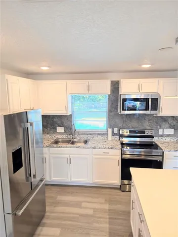 a kitchen with stainless steel appliances a stove a sink and a refrigerator