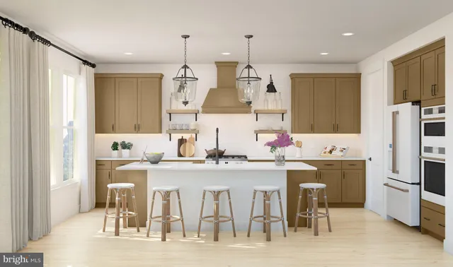 a kitchen with stainless steel appliances kitchen island granite countertop a table chairs stove and refrigerator