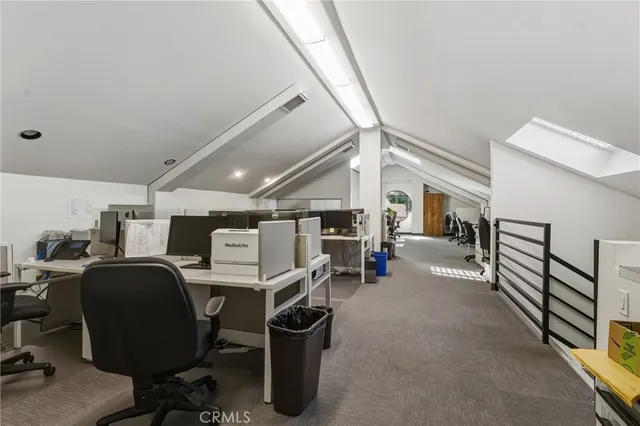 a view of a workspace with furniture and a window