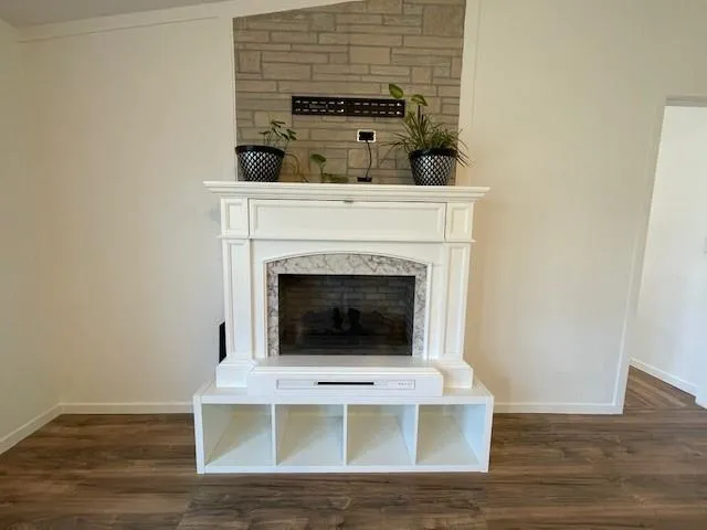 a living room with a fireplace and wooden floor