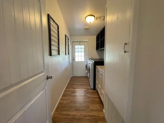 a view of a hallway with wooden floor and staircase