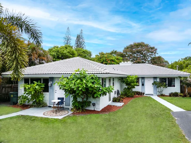 a front view of a house with a garden and plants