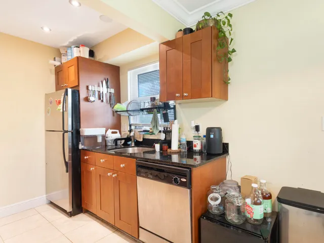 a kitchen with granite countertop a sink stove and refrigerator