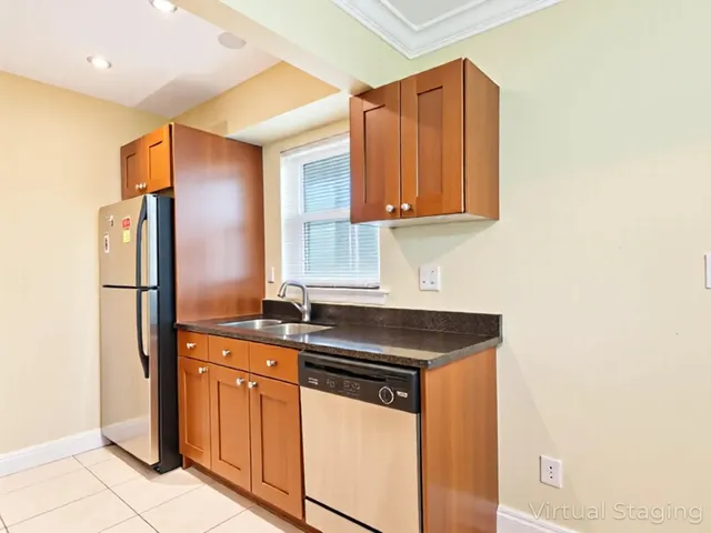 a kitchen with stainless steel appliances granite countertop a sink and a refrigerator