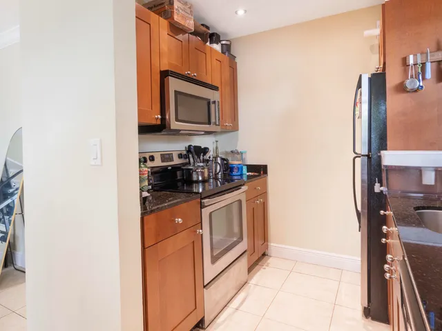 a kitchen with stainless steel appliances granite countertop a refrigerator and a stove top oven