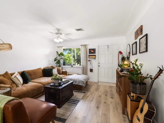 a living room with furniture flowerpot and wooden floor