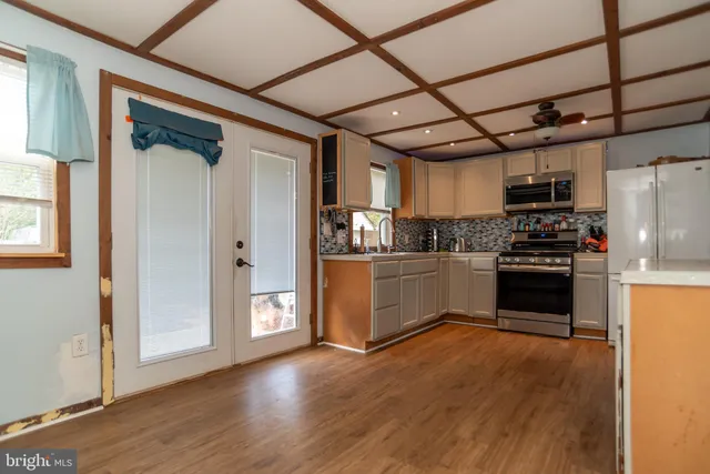 a kitchen with granite countertop a refrigerator and a stove top oven