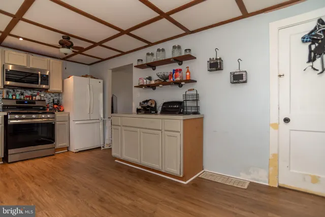 a kitchen with cabinets and wooden floor