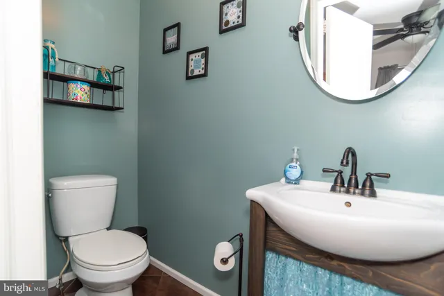 a bathroom with a toilet a sink and mirror