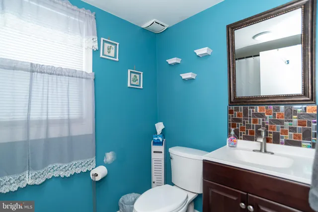 a bathroom with a sink a toilet and mirror