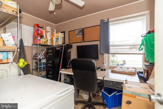 a view of a workspace with furniture and a window