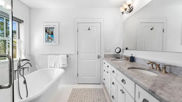 a bathroom with a granite countertop sink mirror and a bathtub