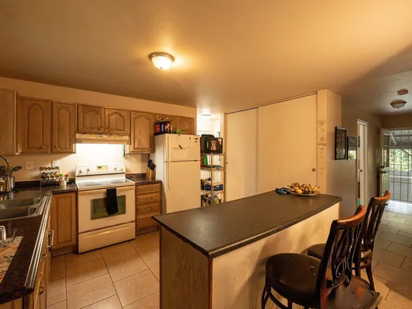 a kitchen with kitchen island a stove a table and chairs