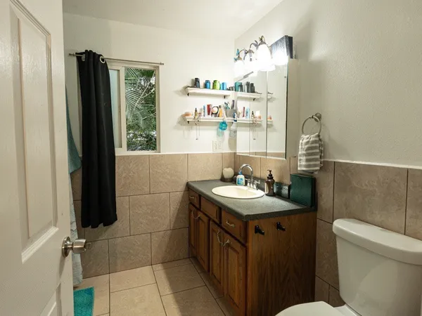 a bathroom with a sink a toilet and a mirror