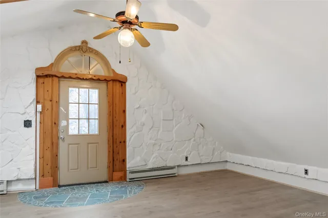 an empty room with windows and fan