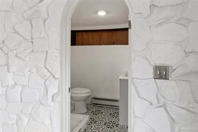 an empty room with windows and exposed radiator