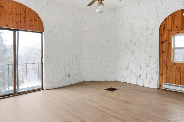 an empty room with wooden floor and door