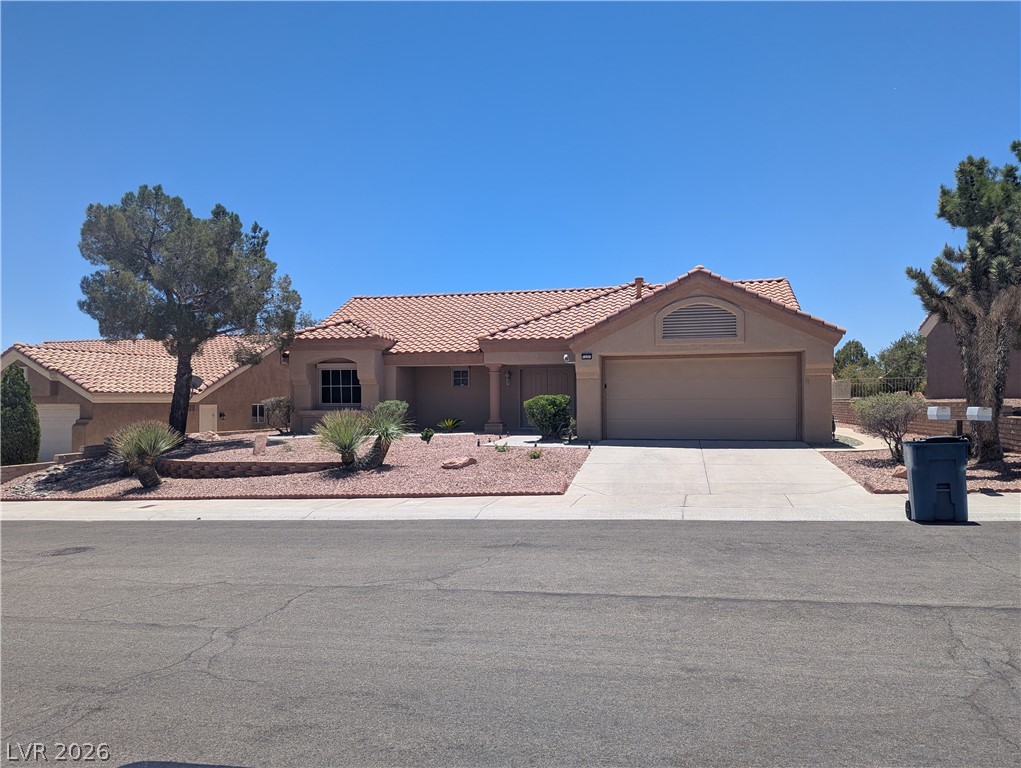 9433 Quail Ridge Drive Las Vegas, NV 89134 - Photo 23 of 23 Well-maintained home featuring a welcoming facade, a large driveway, and desert-friendly landscaping.