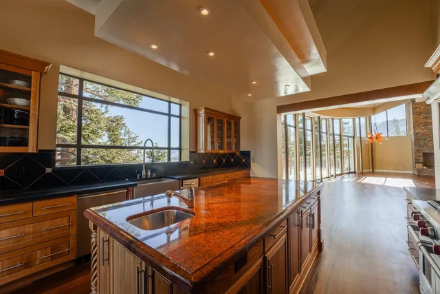 a dining hall with stainless steel appliances granite countertop a sink and a large window