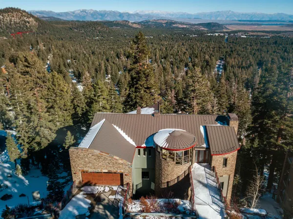 an aerial view of a house with yard and mountain view in back