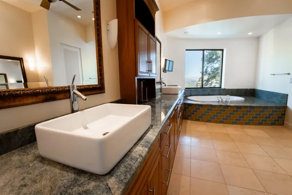 a spacious bathroom with a tub sink and mirror