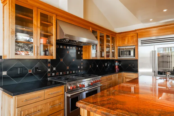 a kitchen with granite countertop a stove and cabinets