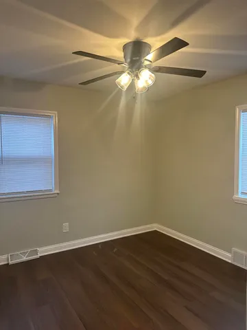 a view of a room with wooden floor and fan