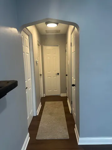 view of a hallway with wooden floor and closet