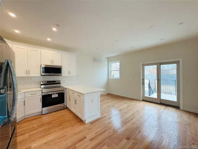 a kitchen with granite countertop a refrigerator and a stove top oven