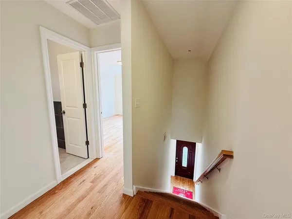 a view of a hallway with wooden floor and staircase