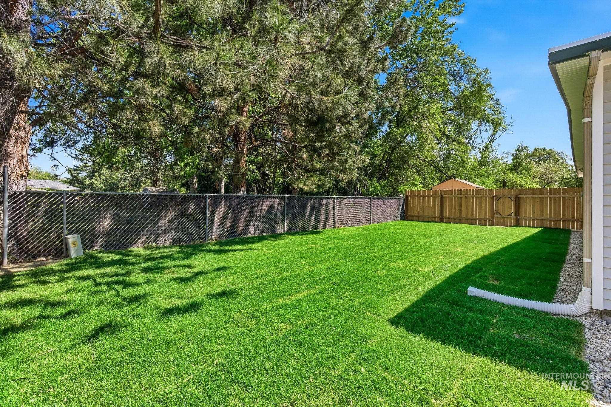 2224 Rachel Circle Boise, ID 83706 - Photo 43 of 50 Expansive backyard featuring a manicured lawn, established perimeter trees, a chain link fence, and a wood privacy fence