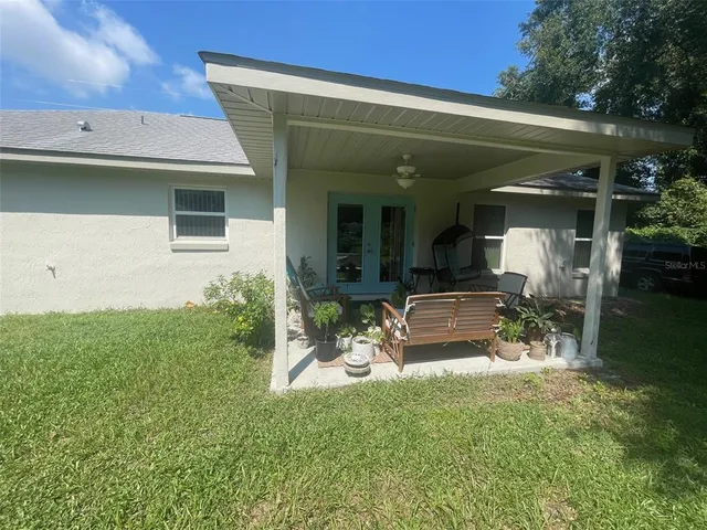 a view of a house with backyard and sitting area
