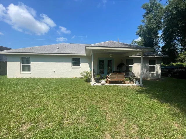 a view of a house with backyard porch and furniture